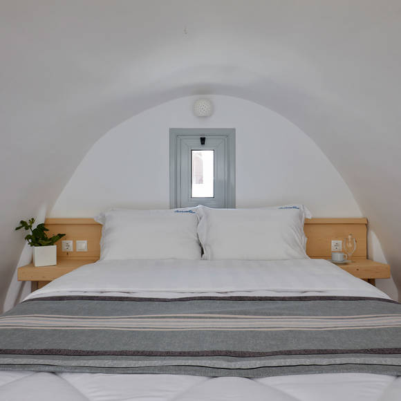 Santorini View Hotel double bed with white and grey linen and bedside tables