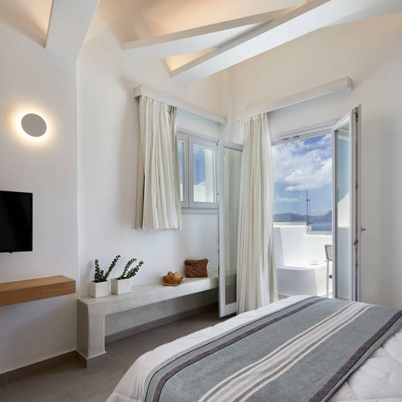 Santorini View Hotel bedroom with double bed, tv, pots with flowers and balcony with aegean sea view