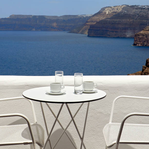 Santorini View Hotel white table seats at a white balcony with sea view