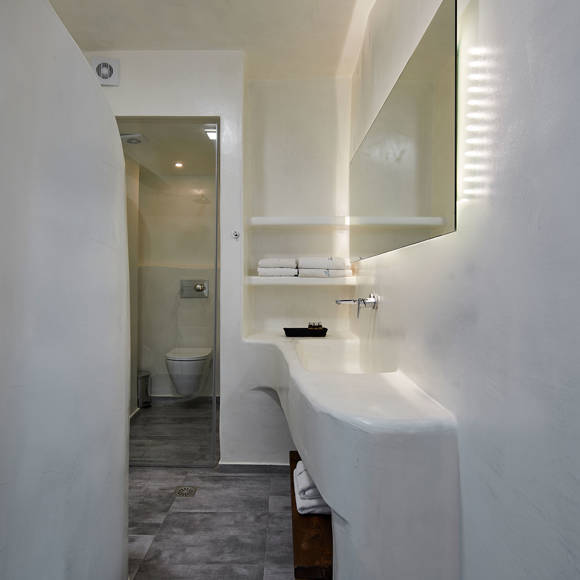 Santorini View Hotel bathroom in white color, a shower, sink and white towels