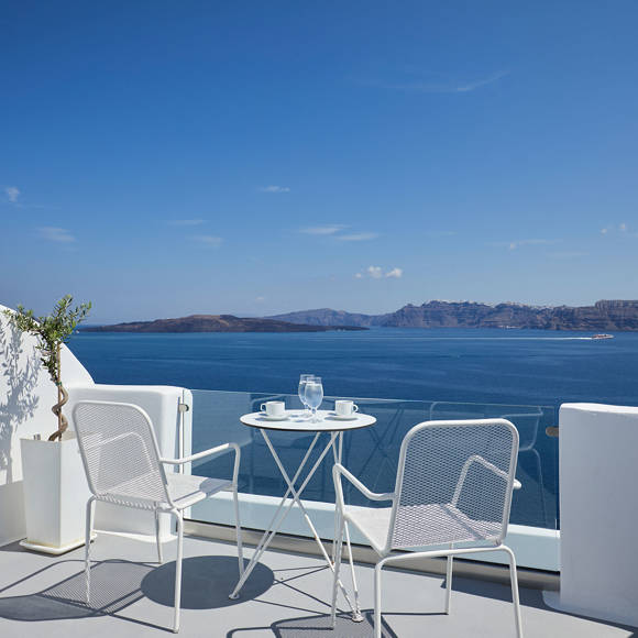 Santorini View Hotel balcony in white colors with furniture and view at the aegean sea