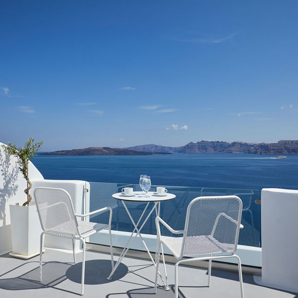 Santorini View Hotel balcony in white colors with furniture and view at the aegean sea