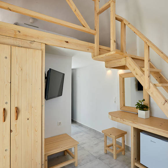 Santorini View Hotel bedroom area with wooden table, mirror and closet