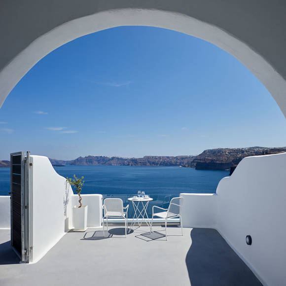 Santorini View Hotel big balcony in white colors with furniture and view at the aegean sea and caldera