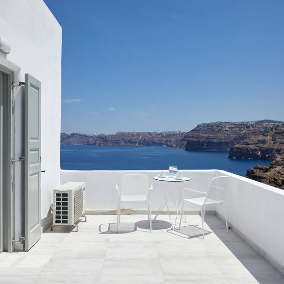 Santorini View Hotel balcony with grey doors, white furniture, table seats and caldera view