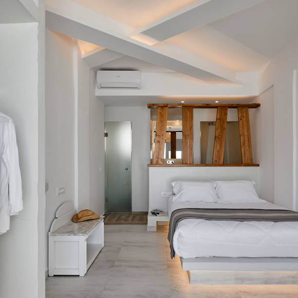 Santorini View Hotel double bed with white linen and grey coverlet, and wooden decoration